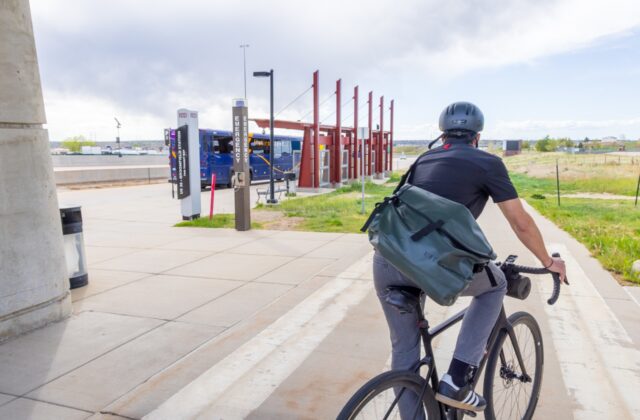 A cyclist rides near the Flatiron Flyer Broomfield gate heading southeast on the US 36 bikeway.